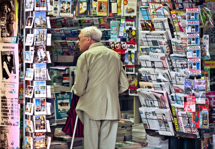 Пожилой мужчина в газетном киоске